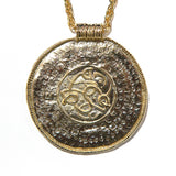 Gold pendant necklace with intricate historic Viking design 
