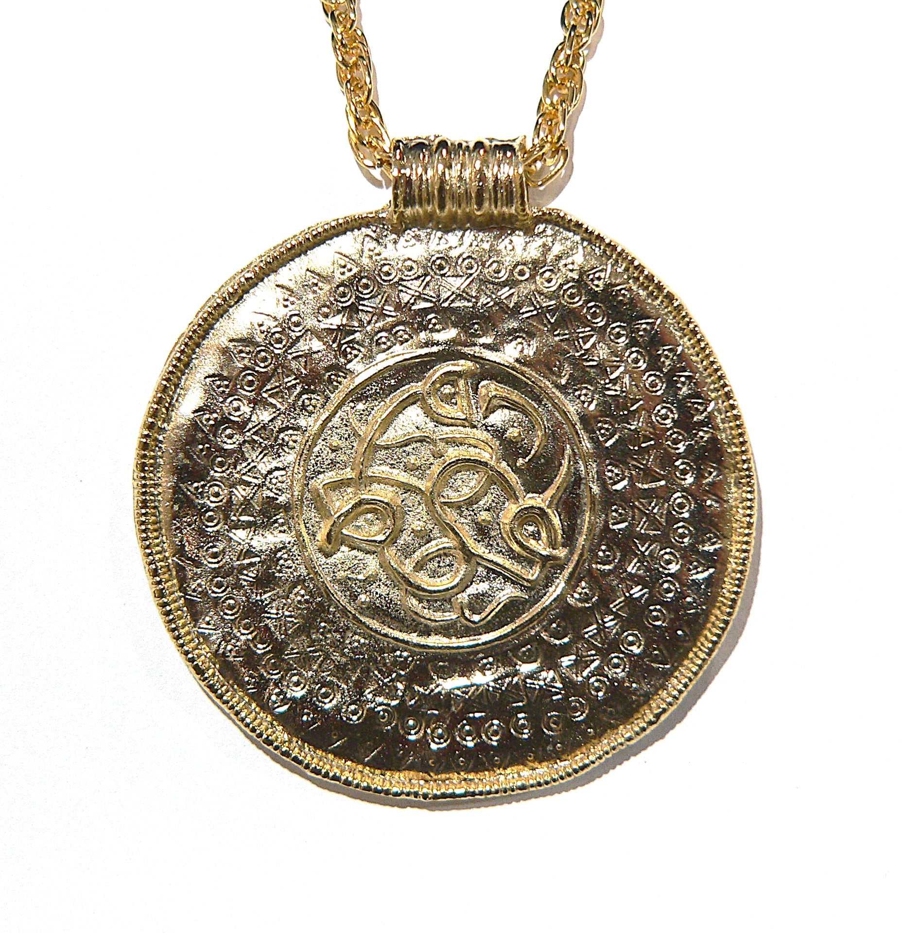 Gold pendant necklace with intricate historic Viking design 
