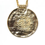Gold pendant necklace with a textured surface and intricate design a Viking reproduction